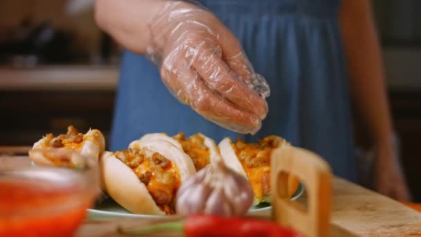 Presione la cebolla roja sobre el queso chili Hot Dogs. Vídeo 4k — Vídeo de stock