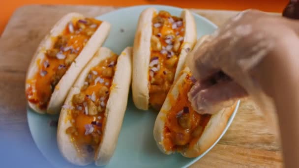 Pressione cebola vermelha sobre chili queijo Hot Dogs. 4k vídeo — Vídeo de Stock