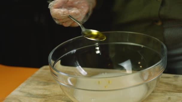 Aku menempatkan sendok makan minyak pada bahan adonan. — Stok Video