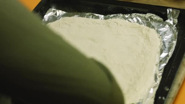 Alumíniumfóliával szórtam szét a tésztát a sütőtálcán. — Stock videók