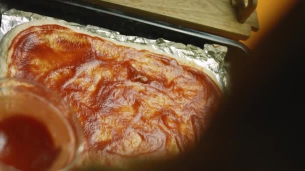 Я намазал пиццу томатной пастой. — стоковое видео