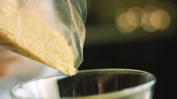 Verander bruine suiker in een helder glas — Stockvideo