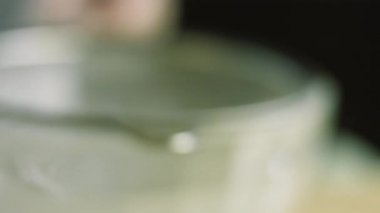 Paslanmaz çelik elek aracılığıyla pudra şekeri veriyorum. Ev yapımı zencefilli kurabiye için krema hazırlıyorum.