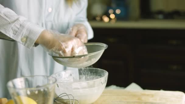 나는 스테인리스강 체를 통해 분말 설탕을 준다. 나는 집에서 만든 생강 쿠키를 위한 크림을 준비 한다 — 비디오