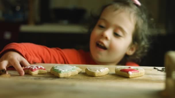 La ragazza mangia felicemente biscotti di pan di zenzero fatti in casa — Video Stock