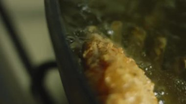 Kızarmış tavuk bacağı ve yağda kanat. Ette baharatlı un tabakası var.