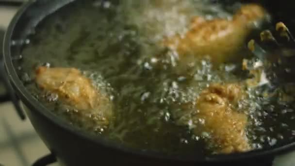 Faire frire les cuisses et les ailes de poulet dans l'huile. La viande a une couche de farine avec des épices — Video