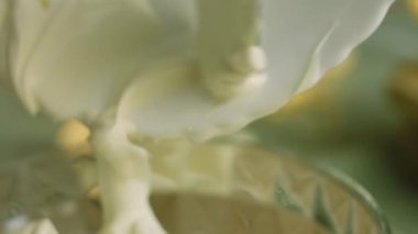 Kâseye pudra şekerli bir kaşıkla ekşi krema ekle. Makro film