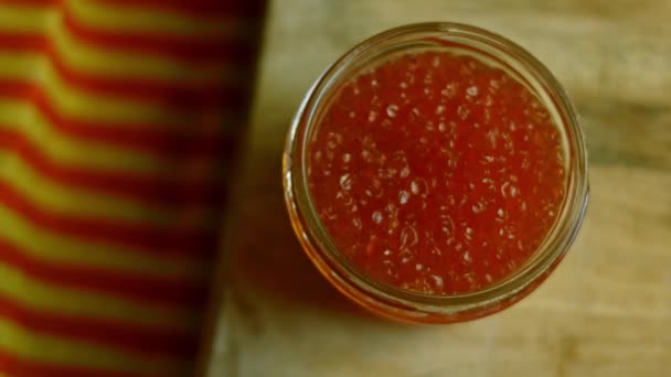 Caviar rojo en una caja de vidrio. Disparos macro — Vídeos de Stock
