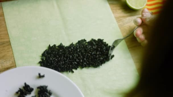 I put the black rice on the spinach tortilla — Stock Video