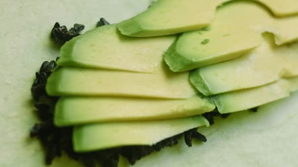 Pune bucăți de avocado pe burrito sushi — Videoclip de stoc