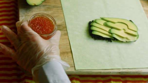 I put a red caviar on the sushi burritos — Stock Video