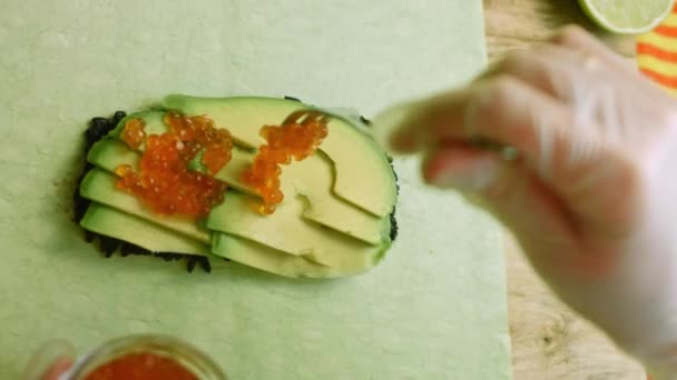 Ich legte einen roten Kaviar auf die Sushi-Burritos — Stockvideo