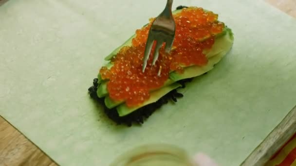 Ich legte einen roten Kaviar auf die Sushi-Burritos — Stockvideo