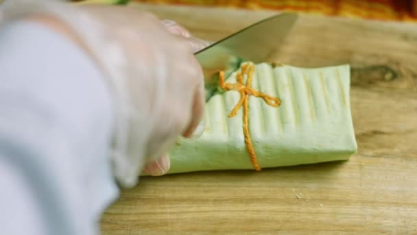 Corte a faca de sushi burritos em dois pedaços — Vídeo de Stock