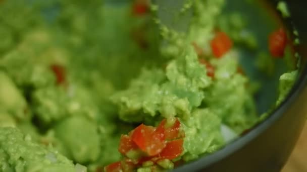 Mezclar los ingredientes de Guacamole con una cuchara. Disparos macro — Vídeos de Stock