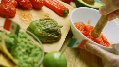 Izgara domatesleri ekleyip doğranmış sarımsakla ezin. Salsa sosunu hazırlıyoruz.