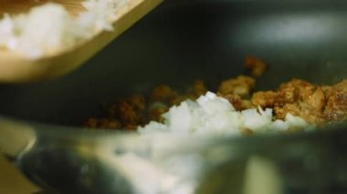 Tavadaki kızarmış sucuk etine doğranmış soğan ve doğranmış biber ekliyorum. Makro çekim