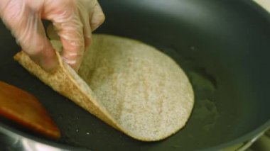Tortilla 'yı diğer tarafa, yağ tenceresine çeviriyorum.