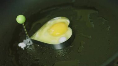 Yemek pişirmek için kalp şeklinde yumurta kızartıyorum. Kapağını kapattım.