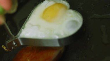 Pişirmek için kalp şeklinde yumurta kızartıyorum.