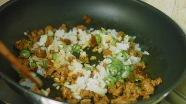잘 게썬 양파, 잘 게썬 후추와 초리 소 고기를 섞는다. 프라이팬에 담긴 튀긴 고기 — 비디오