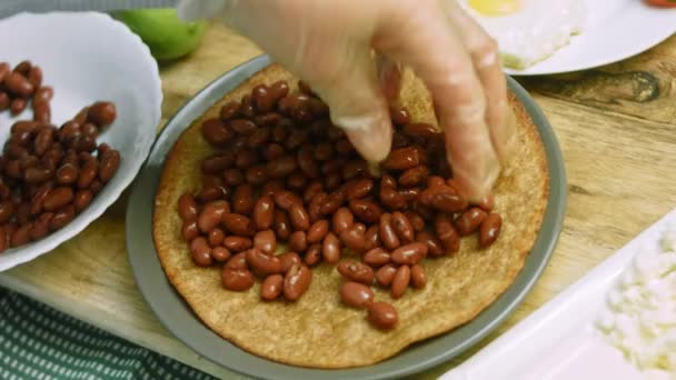 Coloquei os feijões mexicanos na tortilha. Preparação de huevos rancheros — Vídeo de Stock