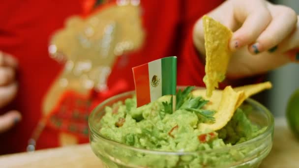 Het meisje proefde de guacamole saus met een nacho — Stockvideo
