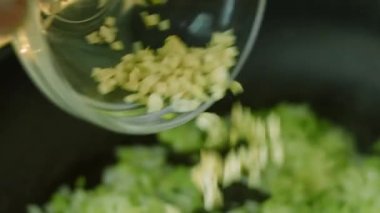 Tavadaki kızartma malzemelerine doğranmış sarımsak ekle. Makro çekim