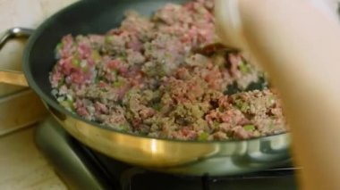 Hindi etiyle tavada kızartılan malzemeleri karıştır. Chili con carne pişir, Meksika mutfağı