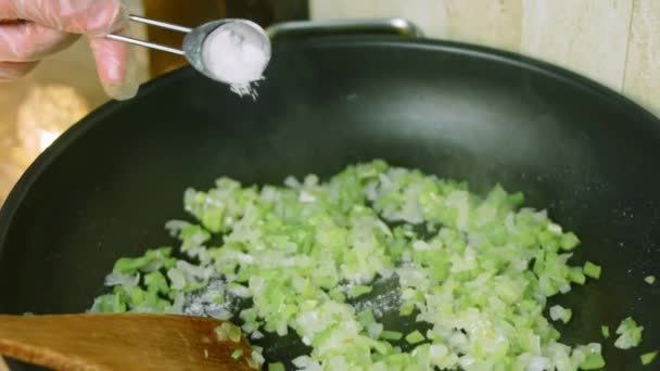 Ponga una cucharada de sal en los ingredientes que se fríen en la sartén. — Vídeos de Stock