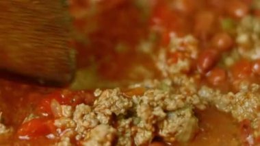 Bütün malzemeleri tahta kaşıkla karıştır. Chili con carne pişir, Meksika mutfağı. Makro çekim