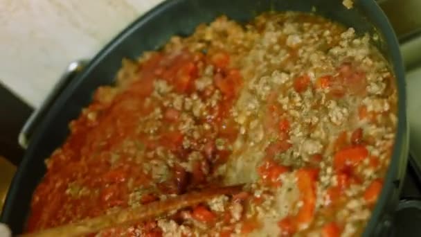 Mezclar todos los ingredientes con una cuchara de madera. Cocinar chile con carne, Cocina Mexicana — Vídeos de Stock