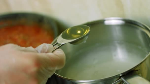 K dlouhé vařené rýži přidejte polévkovou lžíci olivového oleje. V pozadí, vařit chilli con carne. Natáčení maker — Stock video