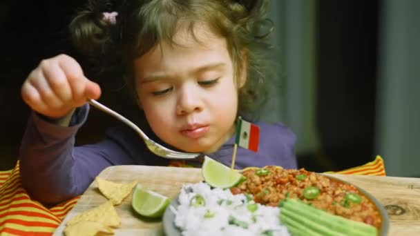 Das Mädchen probiert Chili con Carne mit langem Reis. Aus Truthahn mit belgischem Bier — Stockvideo