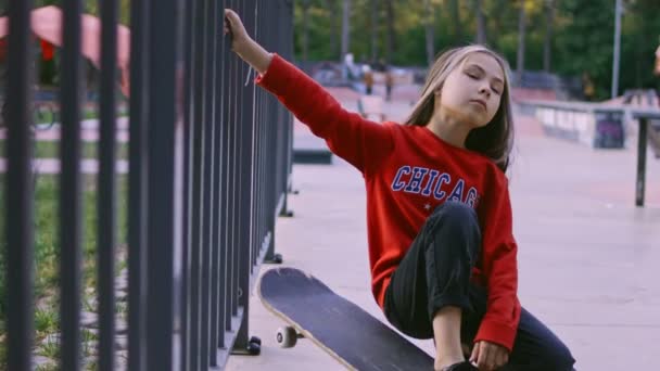 La niña es una modelo profesional posando. Se utiliza un rotulador. Graffiti tierra y pennybord espacio — Vídeos de Stock