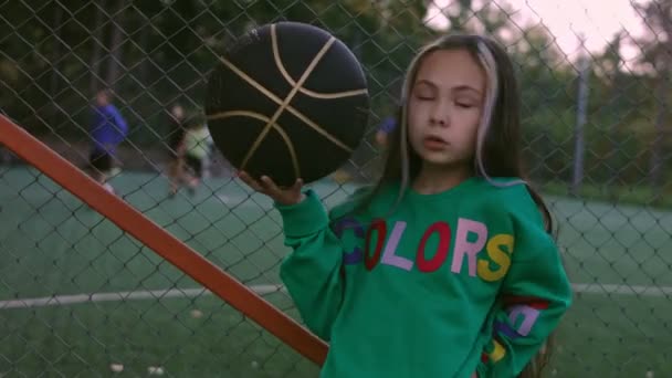 The little girl is a professional model posing. Football court in the background — Stock Video