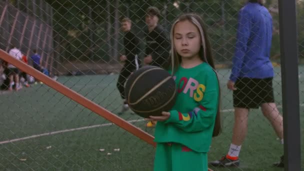 The little girl is a professional model posing. Football court in the background — Stock Video