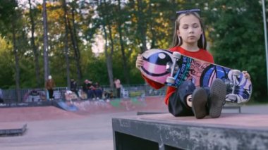 Küçük kız profesyonel bir model. Penboard kullanılıyor. Graffiti arazisi ve Pennybord alanı