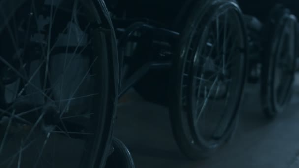 Vue latérale d'un travailleur américain dans un atelier d'une usine fabriquant des fauteuils roulants, assis sur un établi à l'aide d'outils à main et assemblant des pièces d'un produit, assis en fauteuil roulant — Video