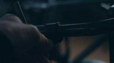 Tekerlekli sandalye üreten, el aletleri kullanan ve bir ürünün parçalarını birleştiren, tekerlekli sandalyede oturan bir fabrikada çalışan Amerikalı erkek işçinin yan görüntüsü.