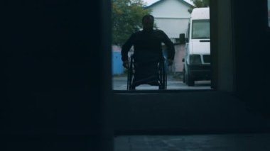 Tekerlekli sandalyeli kişi odaya girer.