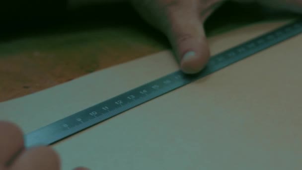 De baard tekent het model om kleding te naaien met een liniaal en een potlood — Stockvideo