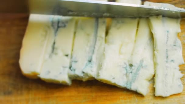 Разрежьте сыр плесенью на квадратные кусочки. Макросъемка — стоковое видео