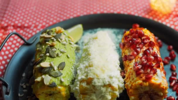 Мексиканская кукуруза краснеет тремя способами. Поглаженный сыром, гуакамоле и гранатом. Максиканский флаг — стоковое видео