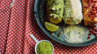 Meksika mısırı üç şekilde elote edilir. Peynir, guacamole ve nar ezilmiş. Kaydırma atışı. Maksimum Bayrak