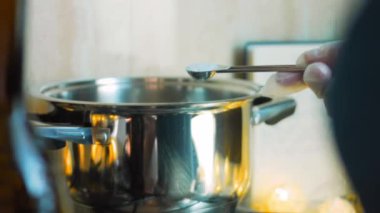 Kaynayan ete bir kaşık tuz ekliyorum.