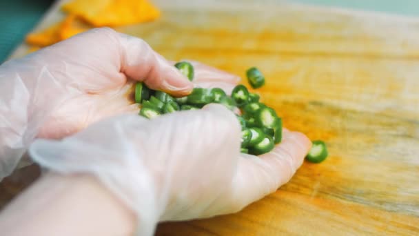 Jag håller i mina händer en chili grön peppar skuren i små bitar — Stockvideo