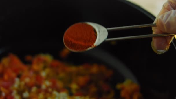 Tillsätt en matsked paprika till ingredienserna i stekt mexikansk soppa — Stockvideo