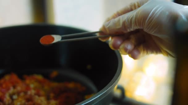 Добавить половину столовой ложки красного порошка чили в ингредиенты для жареного мексиканского супа — стоковое видео